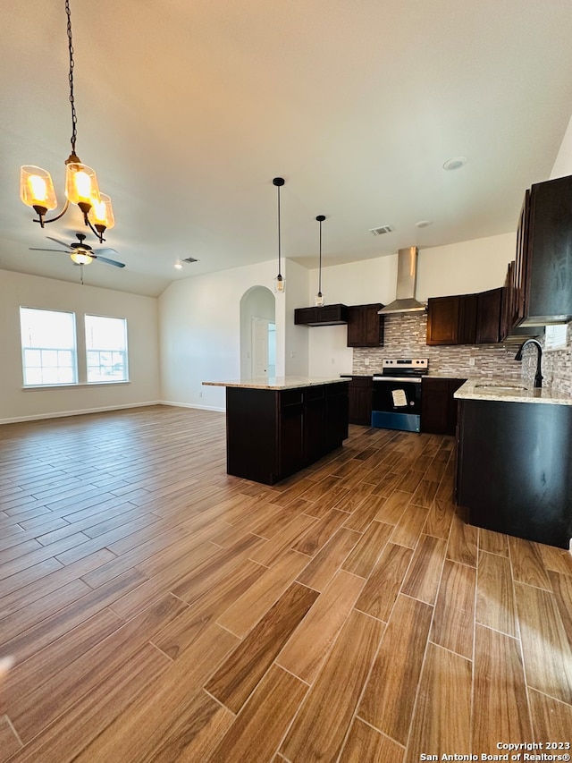 kitchen with electric range, decorative light fixtures, dark brown cabinetry, and wall chimney exhaust hood