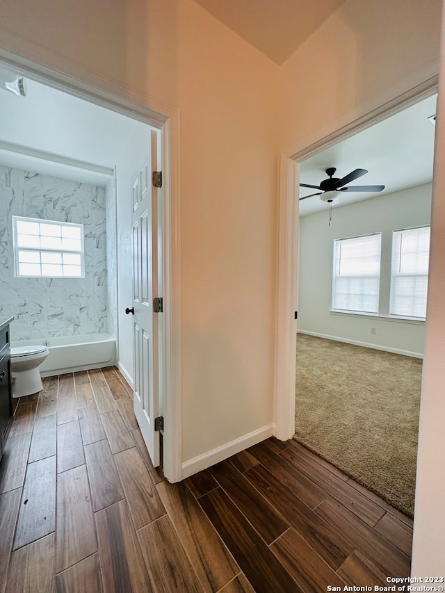 hall featuring dark colored carpet