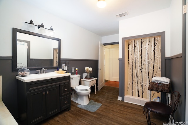 bathroom with toilet, large vanity, and hardwood / wood-style floors