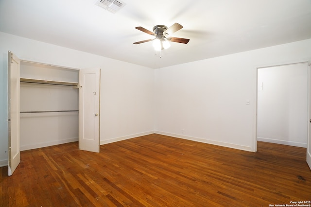 unfurnished bedroom featuring ceiling fan, a closet, and dark wood-type flooring