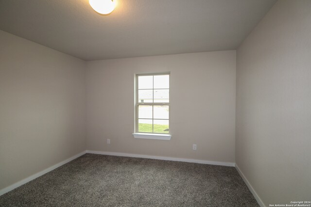 carpeted empty room featuring baseboards