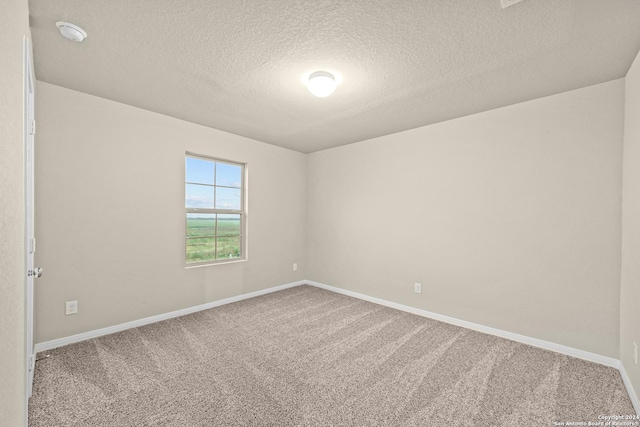 unfurnished room with baseboards, carpet floors, and a textured ceiling