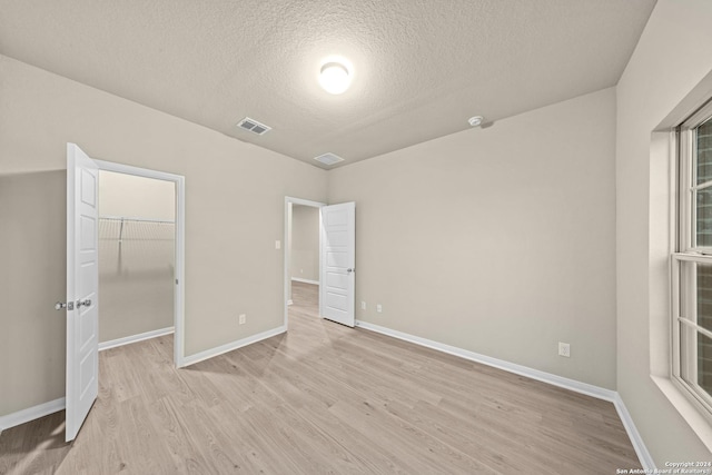 unfurnished bedroom featuring light wood-style floors, visible vents, and baseboards