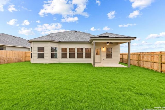 back of house featuring roof with shingles, a lawn, a fenced backyard, a patio area, and a ceiling fan