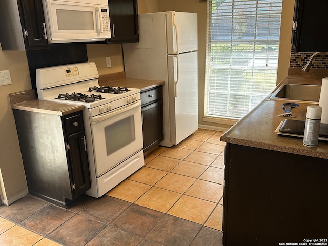 kitchen with white appliances, sink, and light tile floors