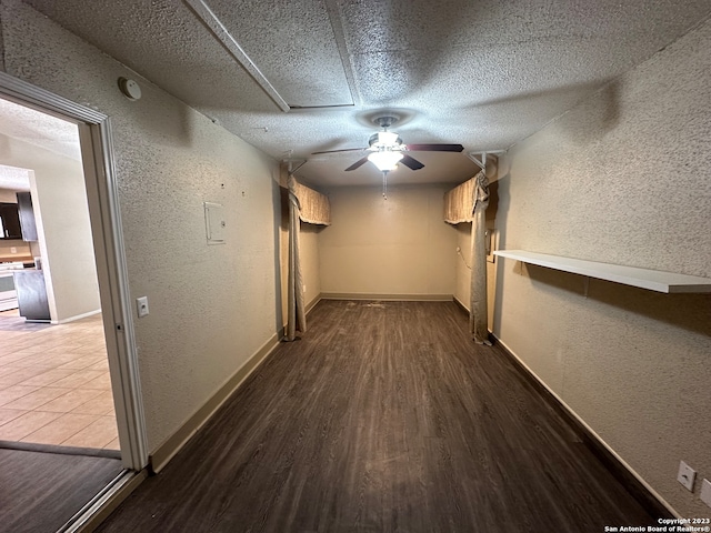 hallway with a textured ceiling and hardwood / wood-style flooring