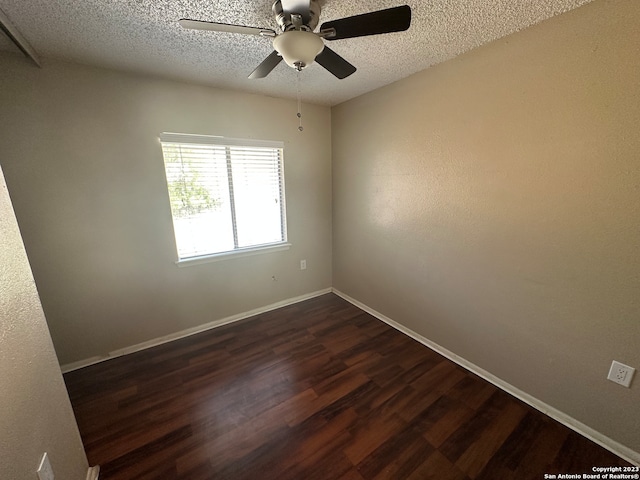 empty room with a textured ceiling, dark hardwood / wood-style floors, and ceiling fan