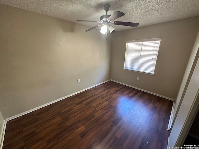 empty room featuring ceiling fan, a textured ceiling, and dark hardwood / wood-style flooring