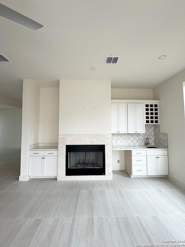 unfurnished living room featuring sink and a fireplace