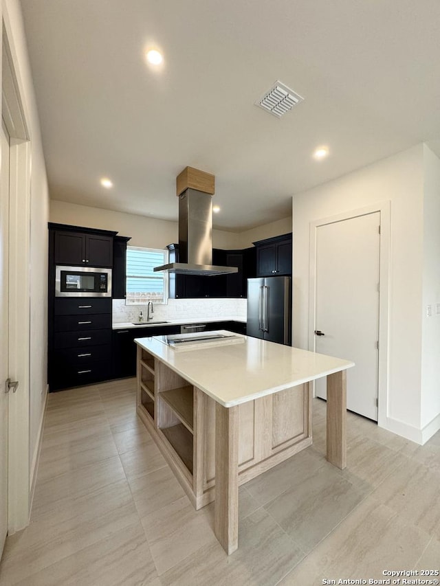 kitchen with a center island, built in microwave, island exhaust hood, tasteful backsplash, and high end fridge