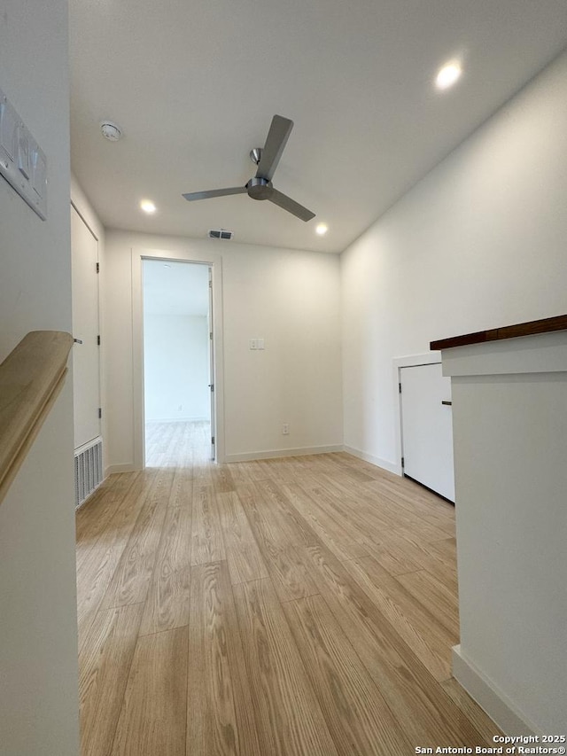 unfurnished living room with light wood-type flooring and ceiling fan