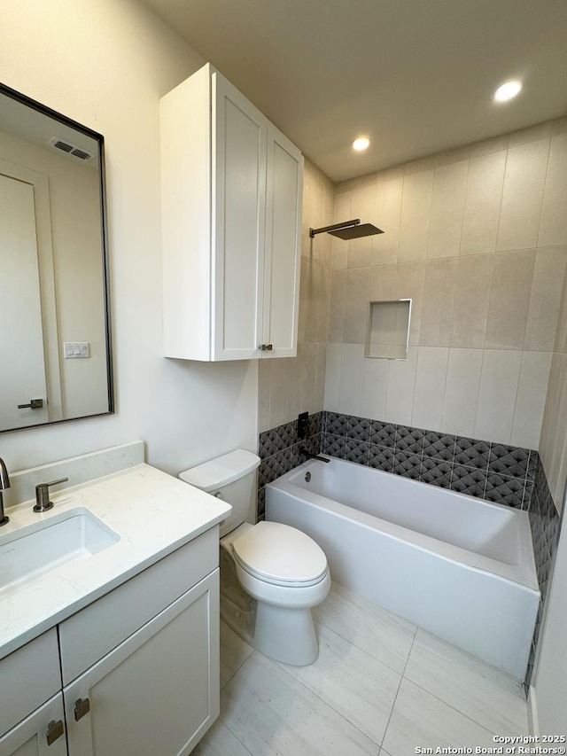 full bathroom featuring toilet, tile patterned flooring, tiled shower / bath, and vanity