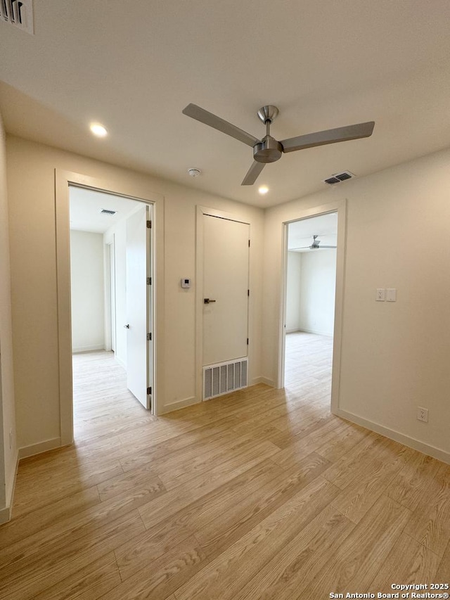 spare room with ceiling fan and light wood-type flooring