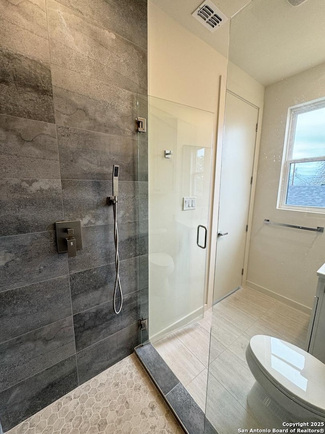 bathroom featuring toilet, tile patterned flooring, a shower with shower door, and vanity