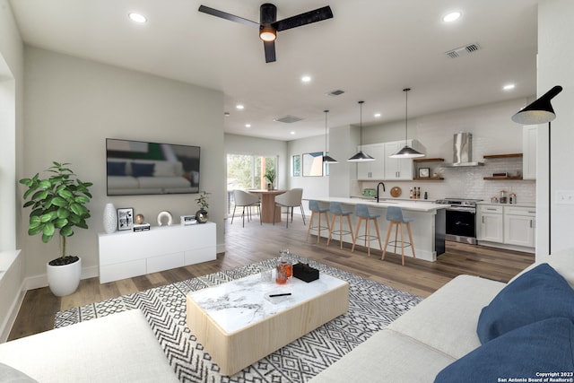 living room featuring dark hardwood / wood-style flooring, ceiling fan, and sink