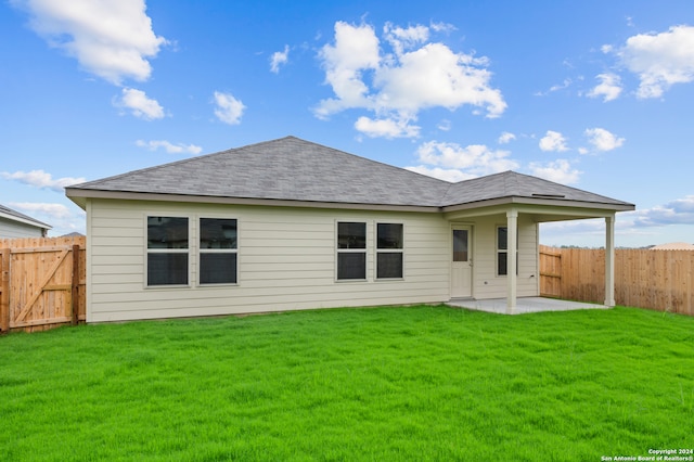 back of property with a patio and a yard