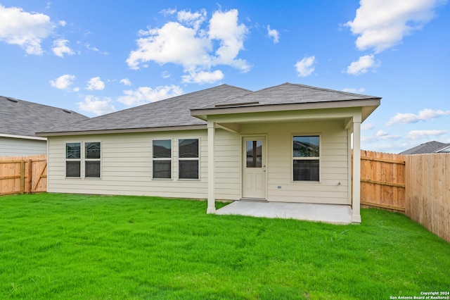 rear view of property with a patio and a yard