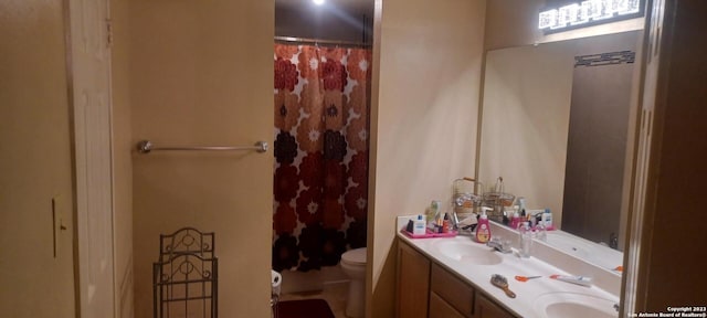 bathroom featuring toilet, double sink, and large vanity