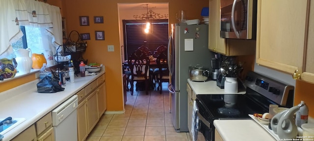 kitchen featuring light tile flooring, pendant lighting, a notable chandelier, and appliances with stainless steel finishes