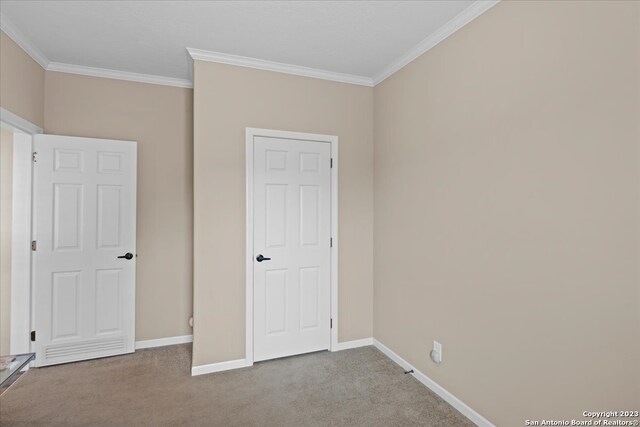 unfurnished bedroom with carpet floors, baseboards, and ornamental molding