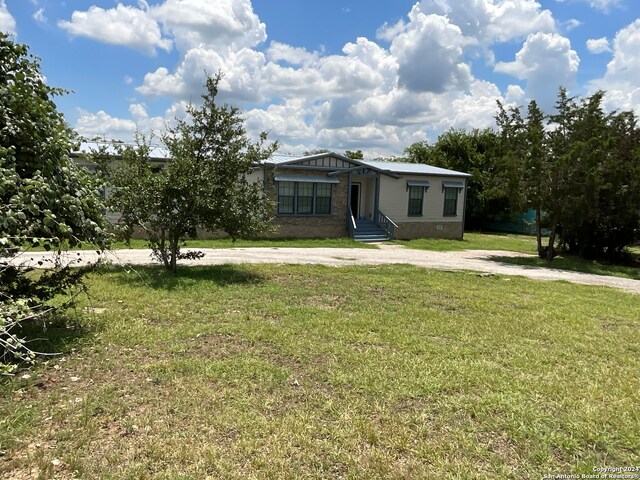 manufactured / mobile home featuring driveway, a front lawn, and crawl space