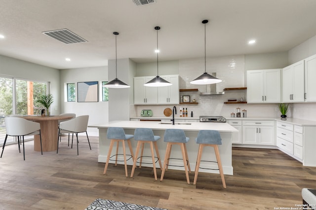 kitchen featuring stainless steel range, sink, dark hardwood / wood-style flooring, decorative backsplash, and white cabinets