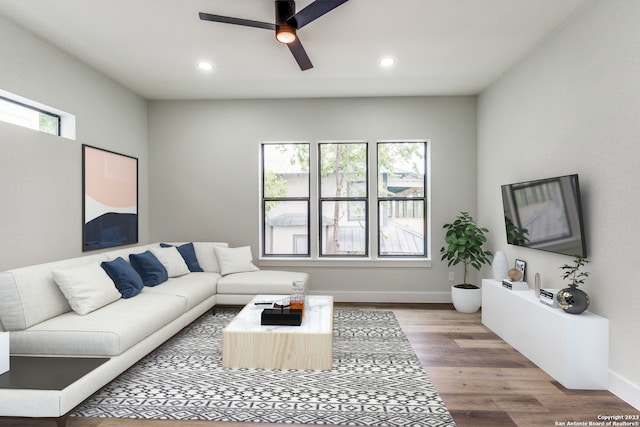 living room with ceiling fan, plenty of natural light, and wood-type flooring