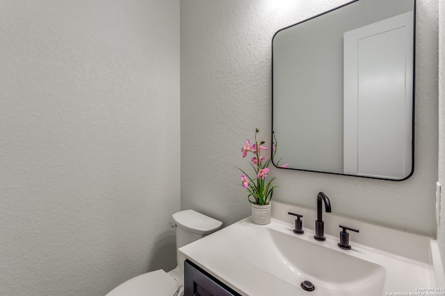 bathroom featuring vanity with extensive cabinet space and toilet