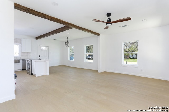 unfurnished living room with light hardwood / wood-style floors, ceiling fan, and beamed ceiling