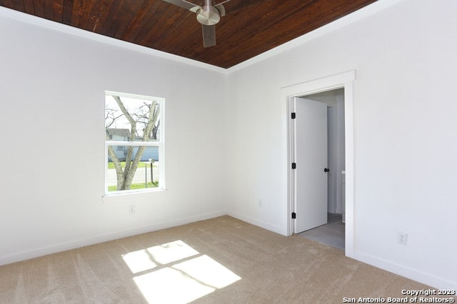 unfurnished room featuring light colored carpet, ceiling fan, wood ceiling, and crown molding