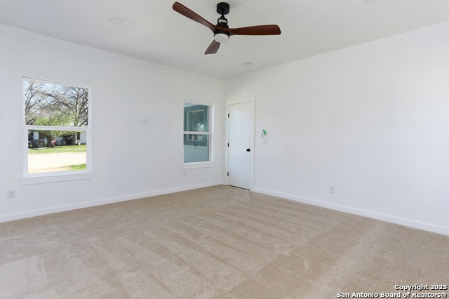 unfurnished room with light carpet and ceiling fan