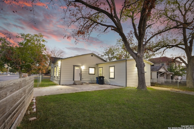 back house at dusk with a yard