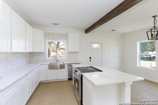 kitchen featuring sink, white cabinets, appliances with stainless steel finishes, light hardwood / wood-style flooring, and backsplash