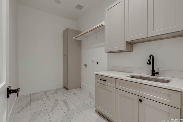 washroom featuring electric dryer hookup, light tile flooring, cabinets, and sink