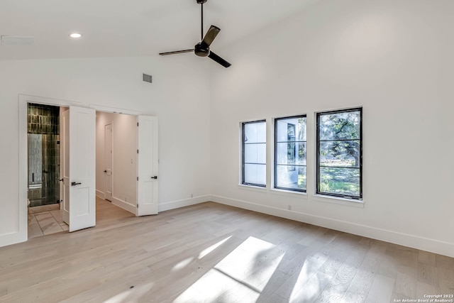 spare room featuring ceiling fan, high vaulted ceiling, and light hardwood / wood-style floors