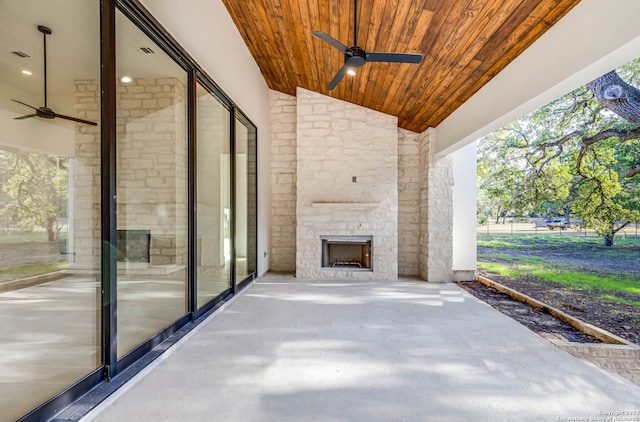 view of patio / terrace featuring ceiling fan and an outdoor stone fireplace