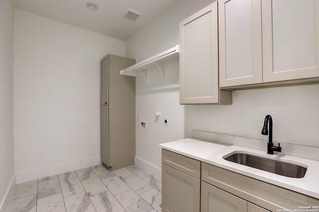 clothes washing area with electric dryer hookup, light tile floors, cabinets, and sink