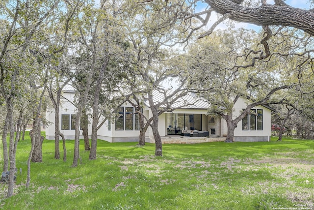 rear view of property featuring a lawn