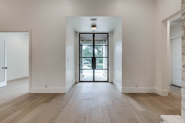 interior space with french doors and light wood-type flooring