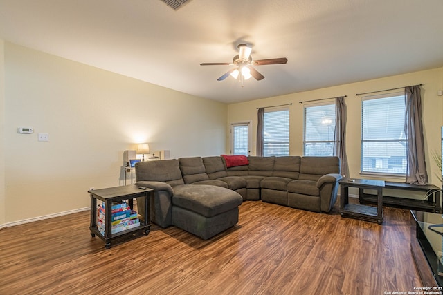 living room with ceiling fan and dark wood-type flooring