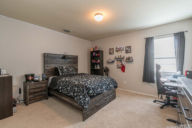 bedroom with light colored carpet and a textured ceiling