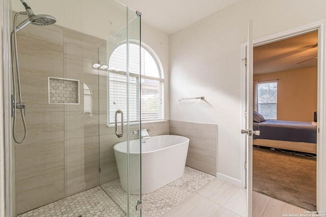 bathroom featuring shower with separate bathtub and tile flooring