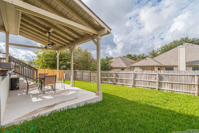 view of yard with ceiling fan and a patio