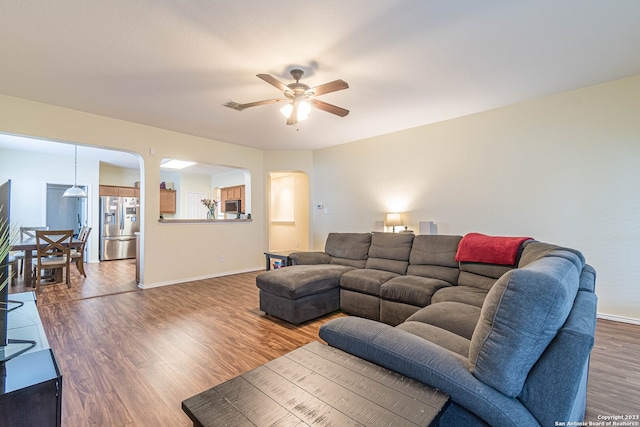 living room featuring ceiling fan and hardwood / wood-style flooring