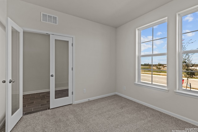 tiled spare room featuring french doors and a healthy amount of sunlight