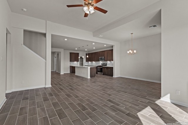 unfurnished living room featuring ceiling fan with notable chandelier, sink, and dark wood-type flooring