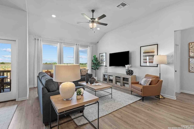 living room featuring wood-type flooring, ceiling fan, and a wealth of natural light