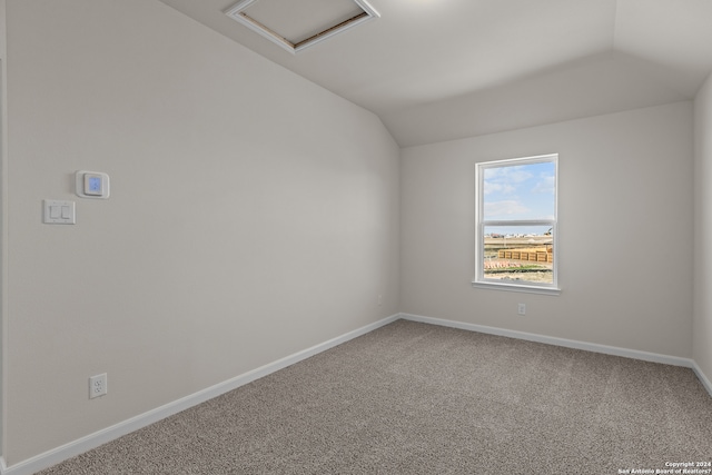 unfurnished room featuring lofted ceiling and light colored carpet