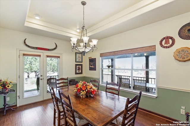 dining room featuring french doors, an inviting chandelier, dark hardwood / wood-style flooring, and a tray ceiling