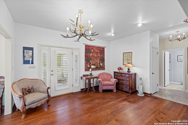 sitting room featuring dark wood-type flooring and an inviting chandelier